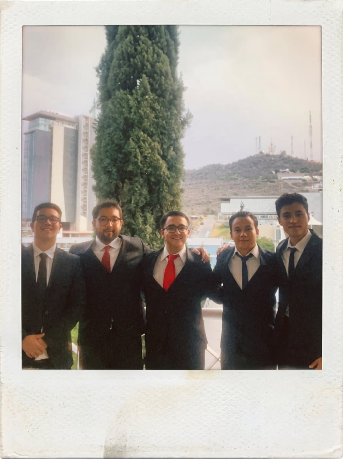 Joseph with four friends in suits on a terrace in León